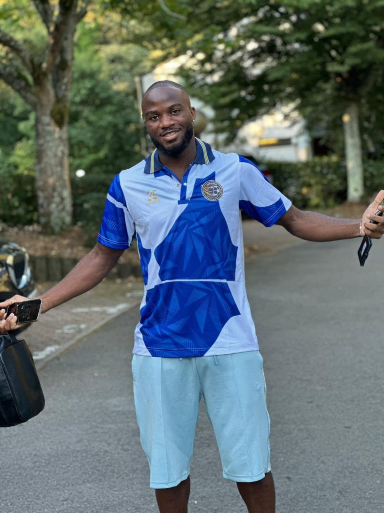 Cameroon International Ganago Reveals His Parents Are Nigerians, Models Shirt Of Simoiben Academy